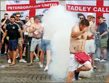  ??  ?? Ugly scenes: Riot police used tear gas to disperse brawling England and Russian supporters