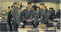  ?? MAYA ALLERUZZO/ASSOCIATED PRESS FILE PHOTO ?? Israeli soldiers look at chairs for hostages held in Gaza at a Passover Seder table on April 11, at the communal dining hall at Kibbutz Nir Oz in southern Israel.