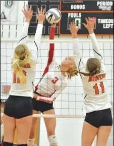  ?? Staff photo/Jake Dowling ?? New Knoxville’s Carsyn Henschen (3) hits the ball over the net while Minster’s Ella Mescher (12) and Jayden Clune (11) attempt to block her.