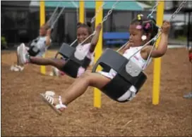  ?? RICK KAUFFMAN — DIGITAL FIRST MEDIA ?? Ariya Nelson, 3, right, and Makayla Hunter, 3, center, play on the swingset Thursday evening at Chester’s newest playground on the corner of Eighth and Lloyd streets.