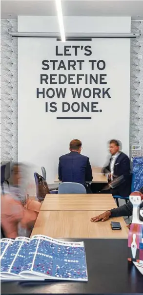  ?? Alberto Bernasconi / Bloomberg ?? A mission statement is displayed on an interior wall as members meet at tables inside the Spaces coworking office.