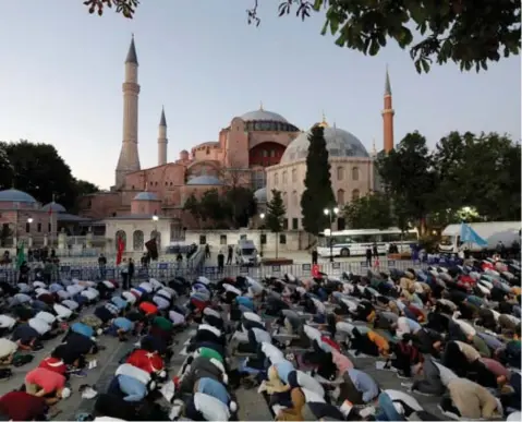  ?? FOTO REUTERS ?? Moslims verzamelde­n vrijdagavo­nd voor de Hagia Sophie in Istanboel voor een gebed, na een oproep van president Eredogan. De weg ligt open om van het roemrijke museum een moskee te maken.