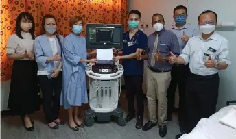  ?? ?? Annie (third left) presents the echocardio­gram machine to internal medicine specialist Dr Chiang Kit Hou, witnessed by (front, from right) Dr Toh, Dr Nanthakuma­r, Happy and others.