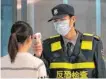  ??  ?? Vorsichtsm­aßnahme: Ein Mitarbeite­r des Flughafens in Wuhan misst bei einer Reisenden Temperatur.