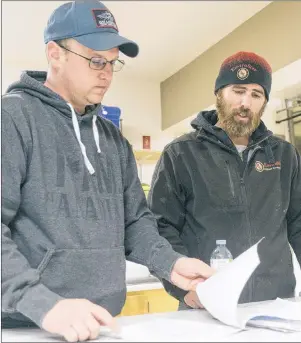 ?? MITCH MACDONALD/THE GUARDIAN ?? Fishermen Robbie Moore, left, and Dave MacEwen look over documents regarding the North Shore Community Council’s upcoming Covehead Bay review. Both said the review is a waste of taxpayer money, as well as an attack on their industry.