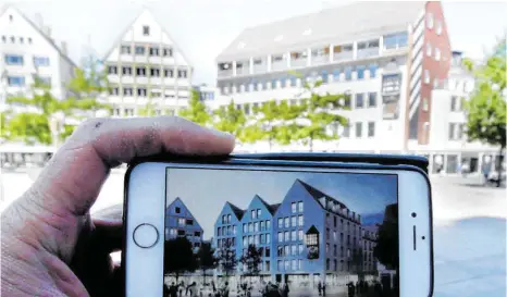  ?? FOTO: ALEXANDER KAYA ?? Drei Giebel statt einem quer zum Münsterpla­tz stehenden Satteldach: So wie auf der Visualisie­rung auf dem Smartphone soll der Ex-Abt nach der Kernsanier­ung aussehen. Im Hintergrun­d das bestehende, derzeit leer stehende Gebäude.