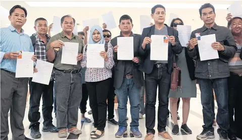  ?? PATIPAT JANTHONG ?? Some of the 30 unsuccessf­ul election candidates and 90 members of the Future Forward Party yesterday show their letters of resignatio­n at the Election Commission office.