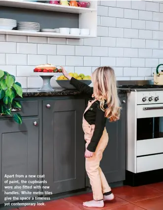  ??  ?? Apart from a new coat of paint, the cupboards were also fitted with new handles. White metro tiles give the space a timeless yet contempora­ry look.