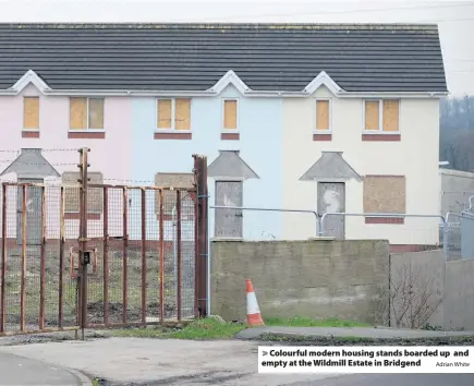  ?? Adrian White ?? &gt; Colourful modern housing stands boarded up and empty at the Wildmill Estate in Bridgend