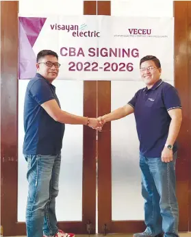  ?? / VECO ?? AGREEMENT. Visayan Electric Company Employees’ Union president Arnel Zapanta, left, and Visayan Electric president and chief operating officer engineer Raul Lucero sealed the five-year Collective Bargaining Agreement between the employees union and the management with a handshake.