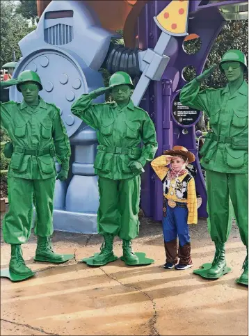  ?? PHOTO BY KATE TUCKWOOD-TAYLOR ?? Attention, young recruit!Sarge and two more green army men give Jack Crowley Edwards the order to salute during his day playing as an “honorary toy” at Toy Story Land.