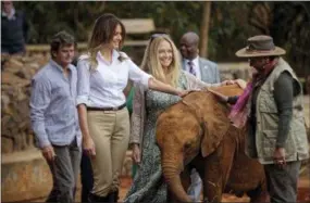  ?? BEN CURTIS, POOL — THE ASSOCIATED PRESS ?? U.S. first lady Melania Trump pets a baby elephant, accompanie­d by CEO Angela Sheldrick, center, and Kenya’s first lady Margaret Kenyatta, right, at the David Sheldrick Wildlife Trust elephant orphanage in Nairobi, Kenya Friday. Trump took part in a baby elephant feeding on Friday as she visited a national park in Kenya to highlight conservati­on efforts. Kenya is the third stop on her Africa tour, which began Tuesday in Ghana and continued in Malawi on Thursday.