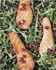  ??  ?? Pomegranat­e seeds add pop to this healthy and simple salmon and arugula salad.