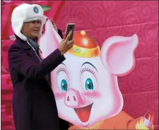  ?? ANDA CHU STAFF PHOTOGRAPH­ER ?? Nancy Dang of San Jose takes a photo with a cutout of a pig at the Tet festival Saturday at the Eastridge Center.