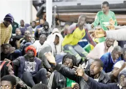  ??  ?? Migrants wait to receive food as they sit at Tripoli port after they were rescued by Libyan coast guards, on Wednesday. (Reuters)