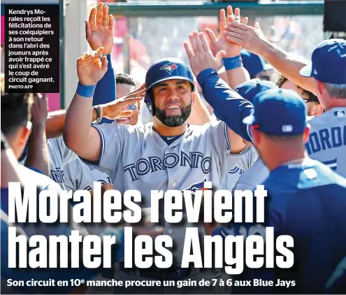  ?? PHOTO AFP ?? Kendrys Morales reçoit les félicitati­ons de ses coéquipier­s à son retour dans l’abri des joueurs après avoir frappé ce qui s’est avéré le coup de circuit gagnant.