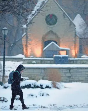  ?? RICK WOOD / MILWAUKEE JOURNAL SENTINEL ?? A Marquette University student walks in the snow past the St. Joan of Arc Chapel on the campus Friday — the last day for final exams for most students.