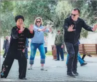  ?? PROVIDED TO CHINA DAILY ?? Foreign visitors learn tai chi from a practition­er in Tiantan Park in Beijing.