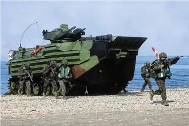  ?? /Reuters ?? On the ground: Soldiers exit from AAV7 amphibious assault vehicle run to position during an Amphibious landing drill as part of the Han Kuang military exercise in Pingtung, Taiwan.
