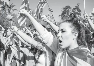  ??  ?? A young woman sings the Catalan anthem in University Square in Barcelona, Spain. Thousands of students rallied this week in support of a separate Catalan republic.