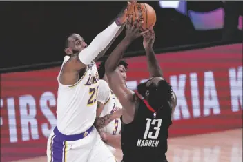  ?? ASSOCIATED PRESS ?? LOS ANGELES LAKERS’ LEBRON JAMES (left) tries to block a shot by Houston Rockets’ James Harden (13) during the first half of an NBA conference semifinal playoff game on Tuesday in Lake Buena Vista, Fla.