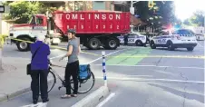  ??  ?? Ottawa Police investigat­e the fatal cyclist collision at the corner of Laurier Avenue West and Lyon Street.