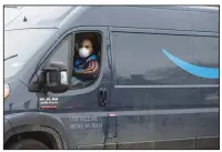  ??  ?? A driver wears a protective mask last week while traveling in an Amazon.com Inc. delivery truck in New Rochelle, N.Y. Amazon Inc. is handling a surge in demand for online orders from customers avoiding stores during the coronaviru­s pandemic. (Bloomberg News/Angus Mordant)