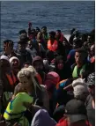  ??  ?? „ Refugees and migrants in an overcrowde­d rubber boat.