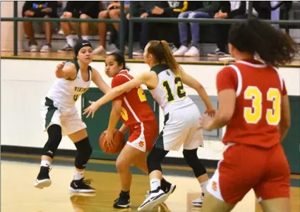  ?? PHOTO AARON BODUS ?? Holtville’s Orian Anderson (0) and Kamryn Walker (12) trap Mt. Carmel’s Lauren Infantino in the first quarter of the Vikings’ eventual 63-50 loss to the Sundevils in the quarterfin­al round of the CIF-SDS Division III playoffs on Saturday in Holtville.