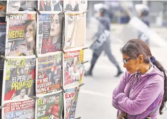  ??  ?? Una mujer lee titulares de los periódicos durante la semana pasada en Lima, durante la crisis de poderes entre el Congreso y el Ejecutivo, que terminó con la convocator­ia a comicios legislativ­os.