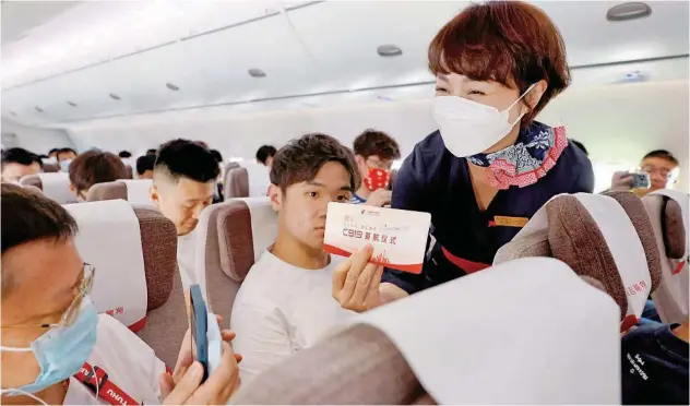  ?? Agence France-presse ?? ↑
A passenger takes photos of a card during the first commercial flight of China’s passenger jet C919 from Shanghai to Beijing on Sunday.