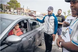  ?? MARKMIRKO/HARTFORD COURANT ?? Trician Salmon, the mother of Jaqhawn Walters, stops while driving past a Main Street memorial to talk with friends of her slain son, including Jerome Harris (second from left) and Eric Crawford (right). Crawford’s son, E.J. Crawford (third from left), who was a college basketball standout at Ionia, gathered with friends today to sign his first profession­al contract at the spot where Walters was murdered.