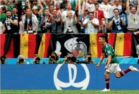  ?? AP ?? Mexico’s Hirving Lozano charges past some stunned German fans after he scores what turned out to be the winning goal in the Group F World Cup match in Moscow.