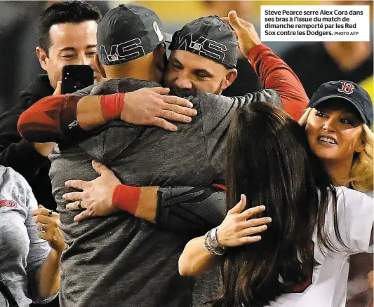  ?? PHOTO AFP ?? Steve Pearce serre Alex Cora dans ses bras à l’issue du match de dimanche remporté par les Red Sox contre les Dodgers.