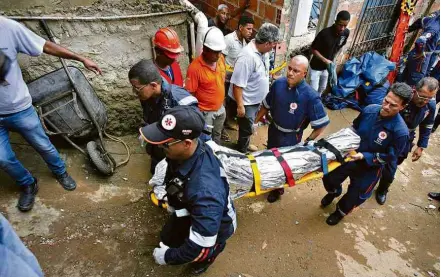  ?? Luciano da Matta/Ag. A Tarde/Folhapress ?? Bombeiros removem corpo de uma das quatro pessoas mortas no desabament­o de um prédio em Pituaçu, em Salvador