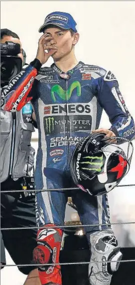  ?? KARIM JAAFAR / AFP ?? Jorge Lorenzo cierra la cremallera de su boca en el podio