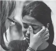  ?? NELSON ALMEIDA /AFP / GETTY IMAGES ?? A student from Raul Brasil public school is comforted while she cries after a shooting took place at the school.