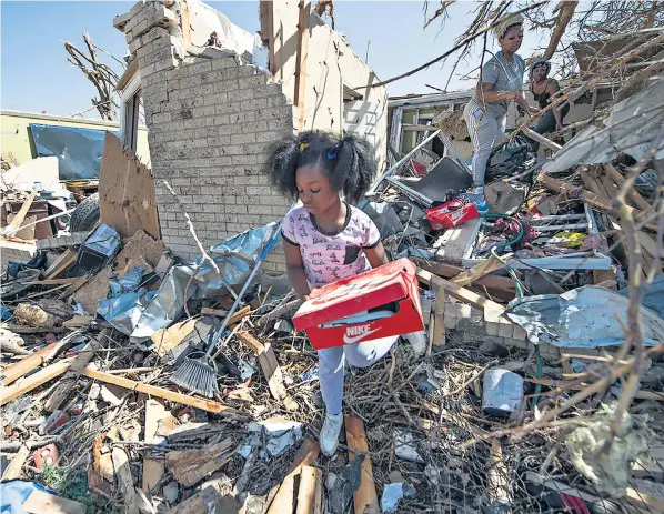  ?? ?? Eight-year-old Alaina Dean and members of her family salvage what they can from their flattened home in Rolling Fork after a tornado struck the Mississipp­i town on Friday night