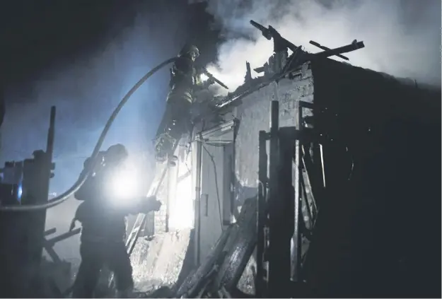  ?? ?? Rescue workers fight a fire in a house destroyed by a Russian drone strike on a residentia­l area in Kharkiv in the early hours of yesterday morning