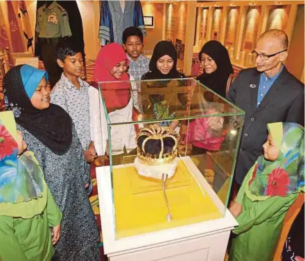  ?? FILE PIC ?? People admiring a regalia at the Special Collection­s of Malay Rulers Exhibition in the Royal Museum, Kuala Lumpur. Malaysia’s most unique feature is that a king is selected every five years.