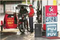  ?? — Reuters ?? A tricycle driver gets his vehicle filled with gasoline at a gas station in Quezon City, Philippine­s.