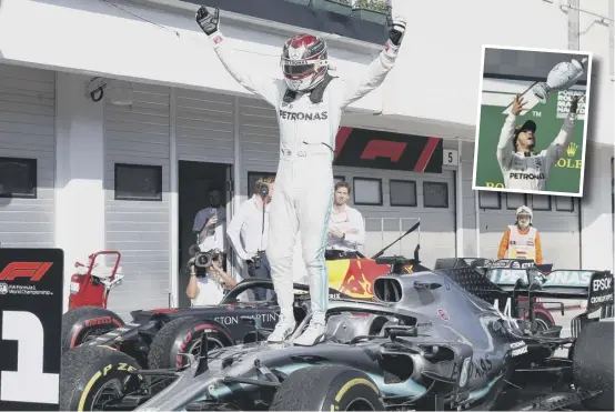  ??  ?? 2 Lewis Hamilton leaps on to the bonnet of his car in celebratio­n following his victory in Hungary. Inset, the British driver throws his trophy into the air in triumph.