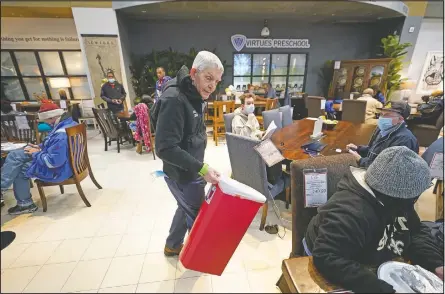  ??  ?? Gallery Furniture store owner Jim McIngvale collects trash inside the business.