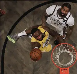  ?? FRANK FRANKLIN II — THE ASSOCIATED PRESS ?? LeBron James (27 points) gets to the basket around the defense of the Nets’ Wilson Chandler on Thursday.