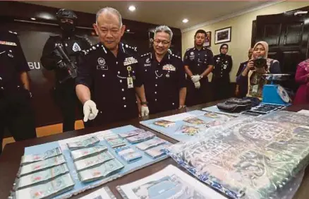  ?? PIC BY IQMAL HAQIM ROSMAN ?? Negri Sembilan police chief Datuk Noor Azam Jamaluddin (second from left) showing the seized items in Seremban yesterday.