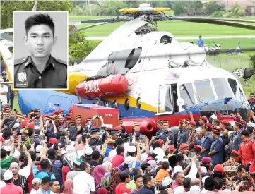  ?? — Bernama photo ?? File photo shows fellow Fire and Rescue Department personnel carrying the coffin out of the helicopter upon landing at Adib’s (inset) hometown.