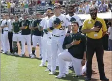  ?? BEN MARGOT, THE ASSOCIATED PRESS ?? The Athletics’ Mark Canha places his hand on the shoulder of Bruce Maxwell as he takes a knee in Oakland on Sunday.