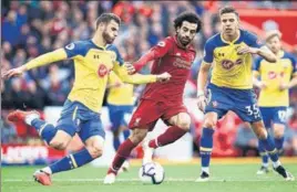  ??  ?? Liverpool’s Mohamed Salah (in red) is challenged by Southampto­n players at Anfield.