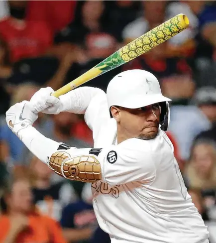  ?? Photos by Karen Warren / Staff photograph­er ?? Yuli Gurriel, who hit a two-run shot in the fifth, wields a pineapple-painted bat while sporting the Astros’ all-white uniform.