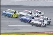  ?? JOHN BAZEMORE — THE ASSOCIATED PRESS ?? Denny Hamlin (11) races William Byron (24) and Matt DiBenedett­o (21) to the finish line during the YellaWood 500 NASCAR auto race at Talladega Superspeed­way, Sunday, Oct. 4, 2020, in Talladega, Ala. Hamlin won.